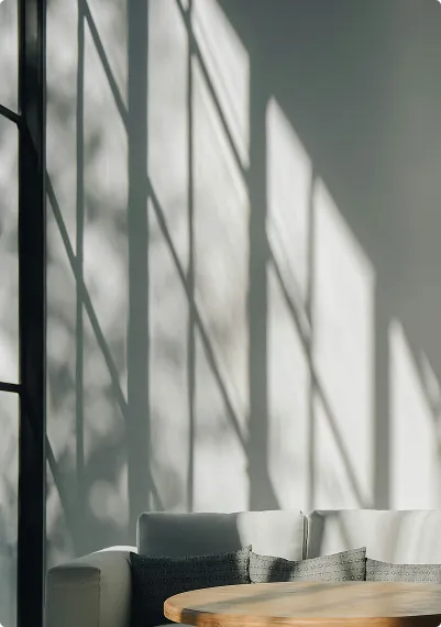 Zonlicht valt op een moderne bank via grote kozijnen in de woonkamer